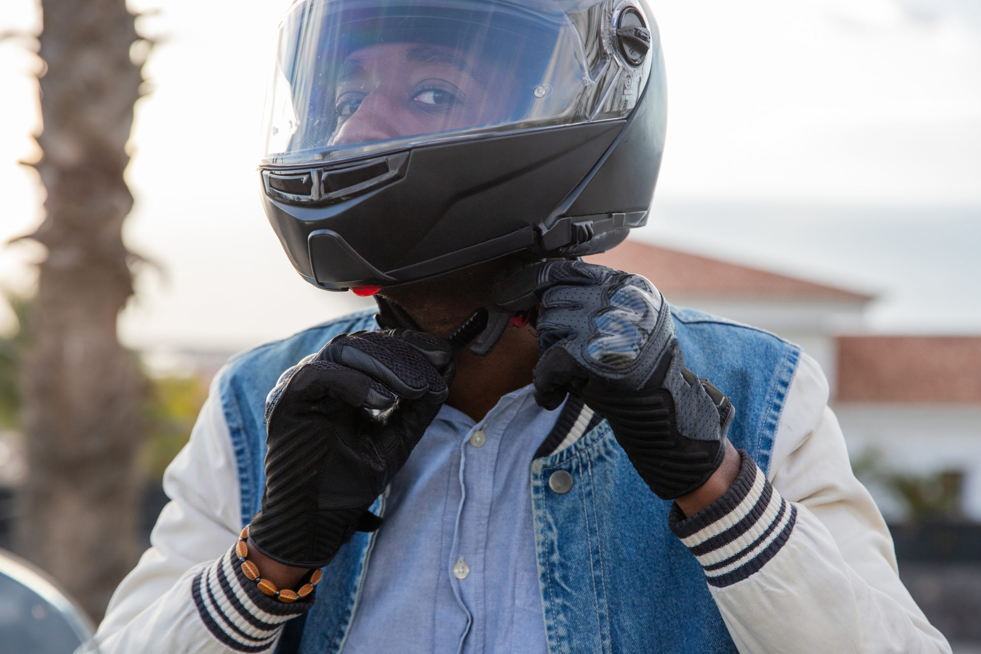 A motorcyclist tightens his helmet belt before driving his motorcycle