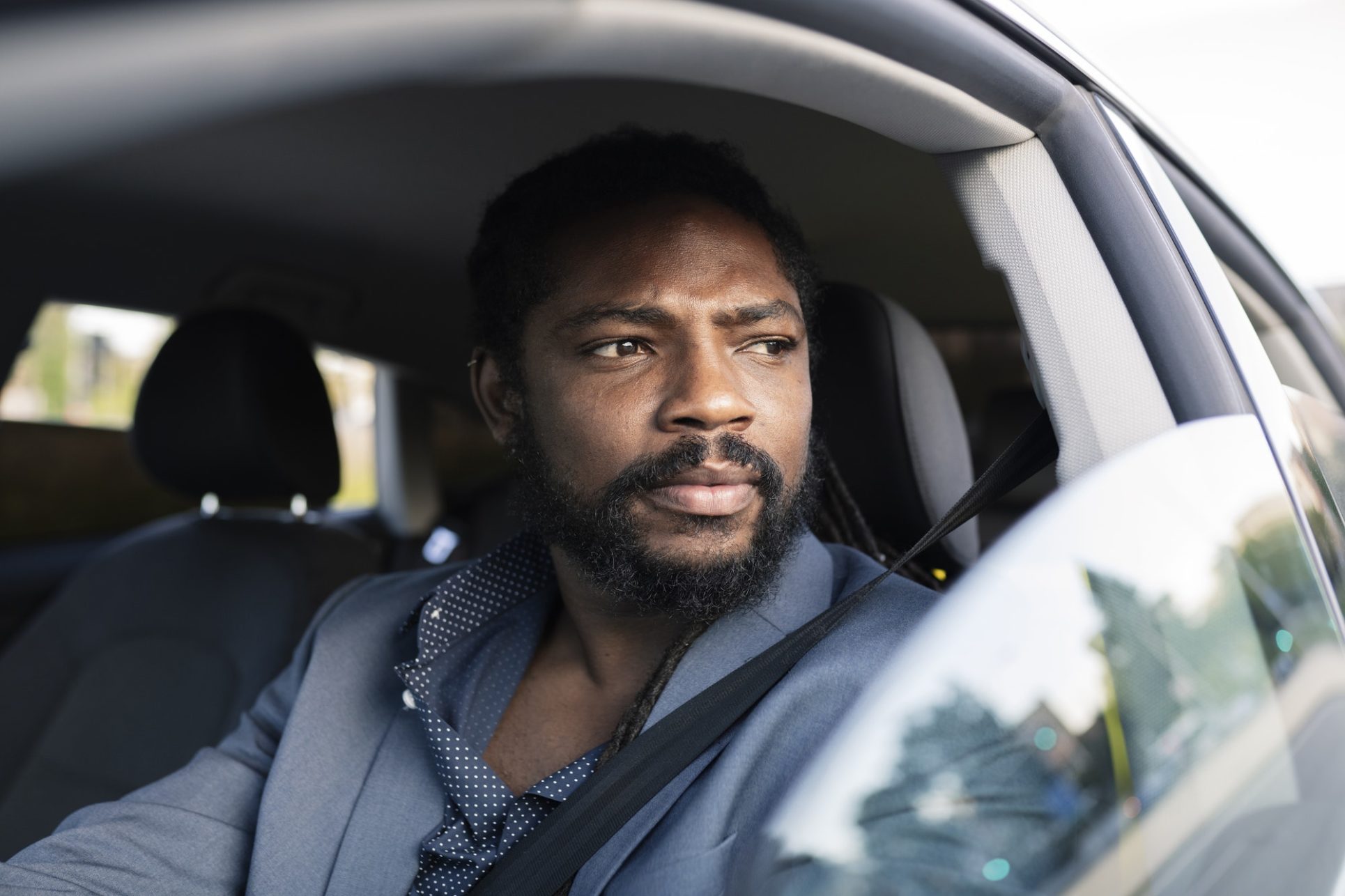 handsome afro american business man driving a car